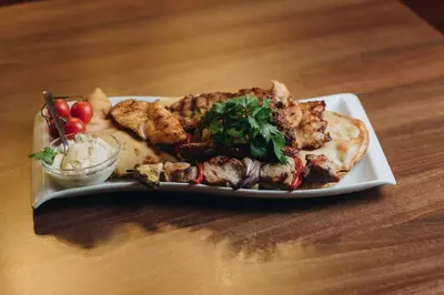 a plate of food with meat and vegetables on a table at Ribarski konaci in Doboj
