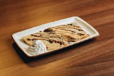 a plate of cake with whipped cream on a table at Ribarski konaci in Doboj