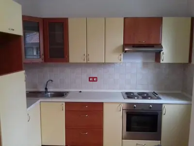 a kitchen with wooden cabinets and a stove top oven at Sound apartment in Fojnica