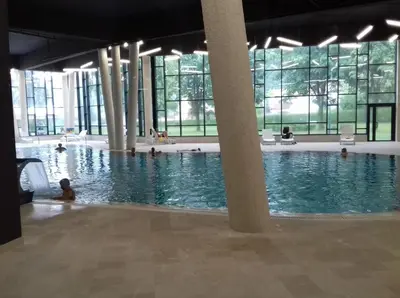 a large swimming pool with people in the water at Sound apartment in Fojnica
