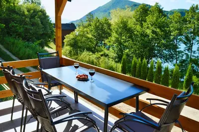 a blue table with two glasses of wine on a porch at Malena Plivsko Jezero Jajce in Jajce