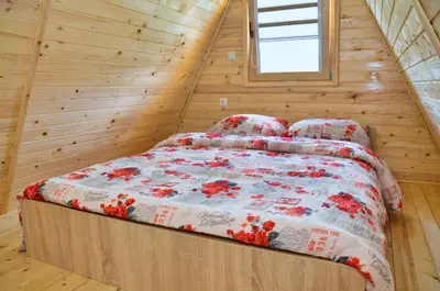 a bedroom with a bed in a wooden cabin at Malena Plivsko Jezero Jajce in Jajce