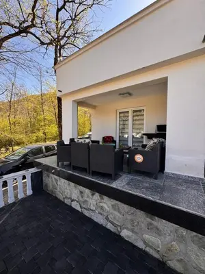 a patio of a house with chairs and a car at Kuća za odmor Aiman in Mahala