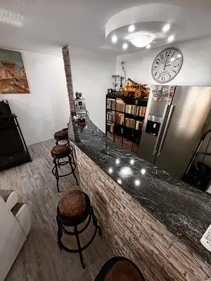 a bar with stools and a clock on the wall at Kuća za odmor Aiman in Mahala