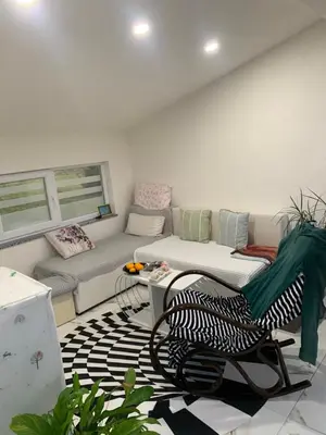 a living room with a couch and a chair at Nisa & De Apartmani in Bihać