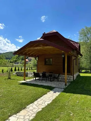 a pavilion with tables and chairs in front of a cabin at Vikendica na Janju in Šipovo