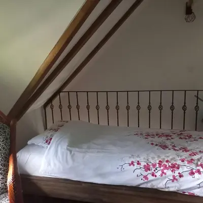 a bed with a white bedspread with red flowers on it at Vikendica na Janju in Šipovo