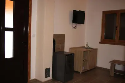 a room with a refrigerator and a tv on the wall at Sherwood resort in Bihać