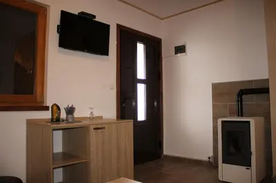 a room with a tv on the wall and a door at Sherwood resort in Bihać