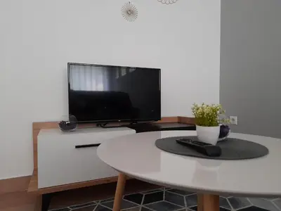 a living room with a white table and a tv at King's Cave in Jajce