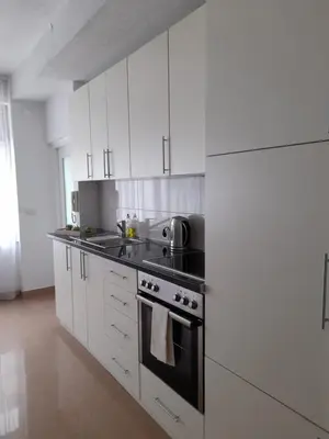 a kitchen with white cabinets and a stove top oven at King's Cave in Jajce