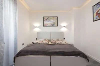 a white bedroom with a bed in a room at Deluxe Feliciano Apartments in Visoko