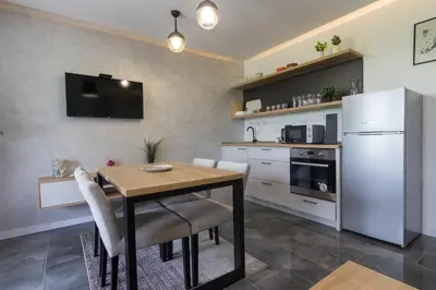 a kitchen with a table and a white refrigerator at Deluxe Feliciano Apartments in Visoko