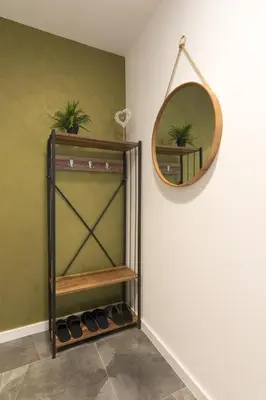 a mirror on a wall next to a shelf with shoes at Deluxe Feliciano Apartments in Visoko