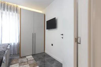 a bedroom with a sliding door with a tv on the wall at Deluxe Feliciano Apartments in Visoko