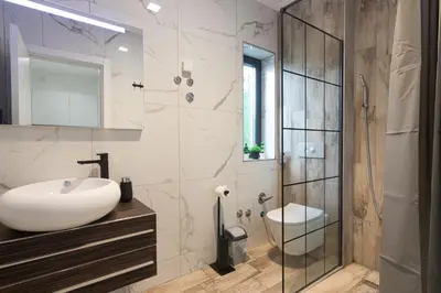 a bathroom with a sink and a glass shower at Deluxe Feliciano Apartments in Visoko