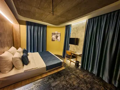 a bedroom with a bed and a desk in it at Hotel City Code in Zenica