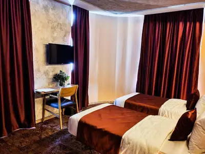 a hotel room with two beds and a desk at Hotel City Code in Zenica