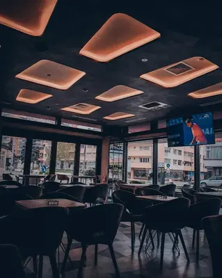 a dining room with tables and chairs and windows at Hotel City Code in Zenica