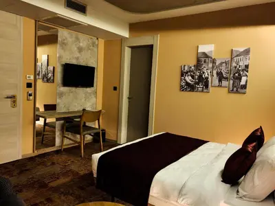 a bedroom with a bed and a table and a mirror at Hotel City Code in Zenica