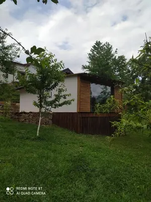 a house in a yard with a tree at Lenilenii Bungalows in Jajce