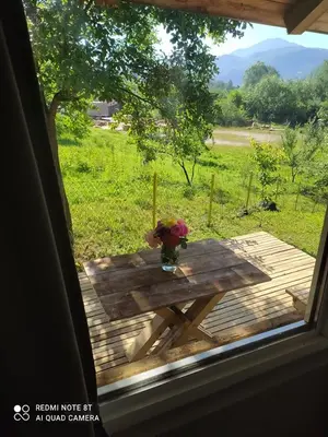 a table with a vase of flowers on top of a window at Lenilenii Bungalows in Jajce