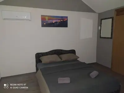 a bed in a bedroom with a picture on the wall at Lenilenii Bungalows in Jajce