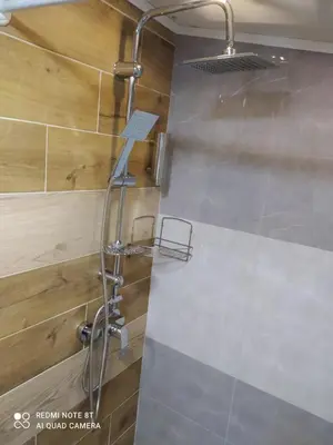 a shower with a shower head in a bathroom at Lenilenii Bungalows in Jajce