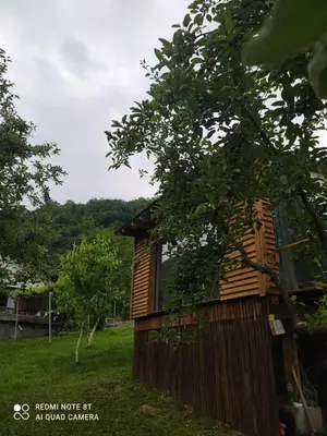 a wooden cabin in a field with trees at Lenilenii Bungalows in Jajce