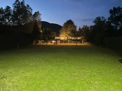 a large field at night with trees and lights at Una Verde in Bihać