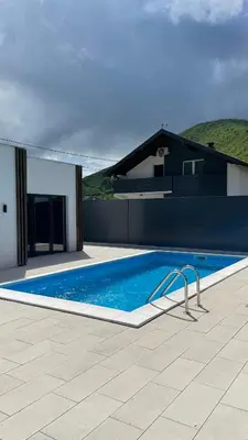 a swimming pool in front of a house at Apartments B&M in Visoko