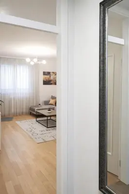 a mirror on a wall in a living room at Loft Lux in Banja Luka