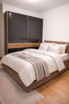 a bedroom with a large bed with a black headboard at Loft Lux in Banja Luka