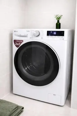 a white washing machine with a plant on top of it at Loft Lux in Banja Luka