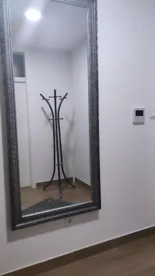 a mirror on a white wall with a tripod at Loft Lux in Banja Luka