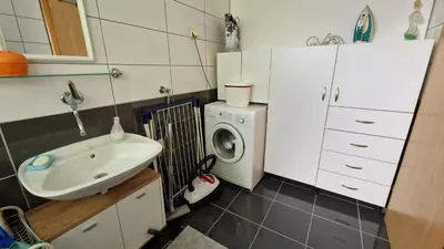 a bathroom with a sink and a washing machine at TUZLA ViVa 2 in Tuzla