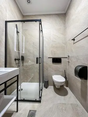 a bathroom with a shower and a toilet and a sink at Hotel Vidović in Banja Luka