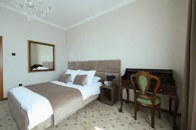 a bedroom with a bed and a desk and a chair at Hotel Vidović in Banja Luka