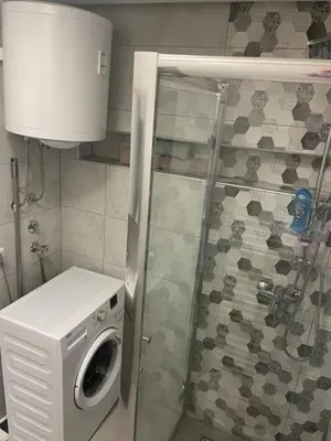 a washing machine in a bathroom with a shower at Central 13 in Tuzla