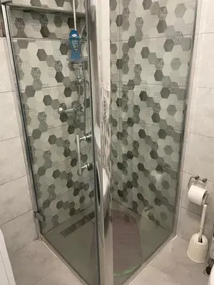 a shower with a glass door in a bathroom at Central 13 in Tuzla