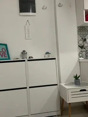 a white cabinet in a room with a table at Central 13 in Tuzla