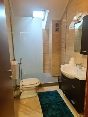 a bathroom with a white toilet and a sink at Aventurin Superior Apartments in Bihać
