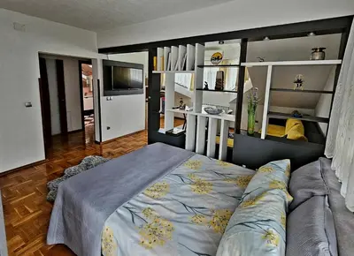 a bedroom with a bed and a television in it at Aventurin Superior Apartments in Bihać