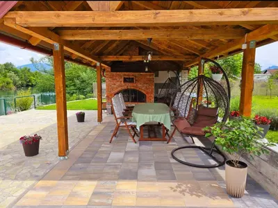 a covered patio with a table and a swing at Aventurin Superior Apartments in Bihać