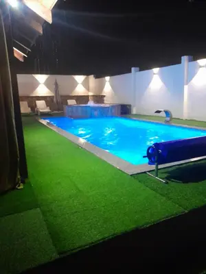 a large swimming pool with green grass in a building at Villa Panorama in Bihać