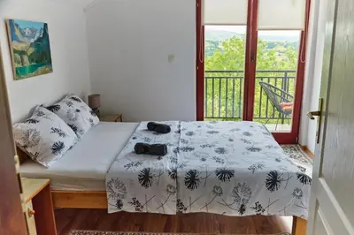 a bedroom with a bed and a balcony at Guest house Al Meri in Travnik