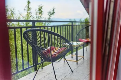a black chair sitting on a balcony next to a fence at Guest house Al Meri in Travnik