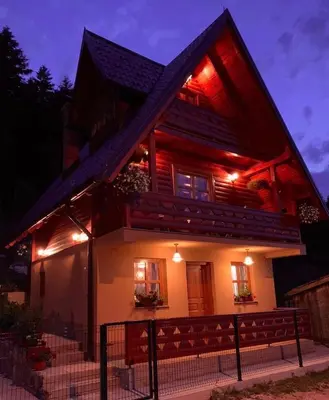 a house lit up at night with lights at Planinska kuca za odmor-Mlinista in Landeke