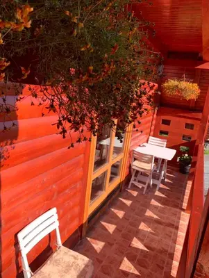 a patio with two chairs and a table on a building at Planinska kuca za odmor-Mlinista in Landeke