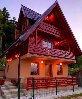 a house with red lights on the front of it at Planinska kuca za odmor-Mlinista in Landeke